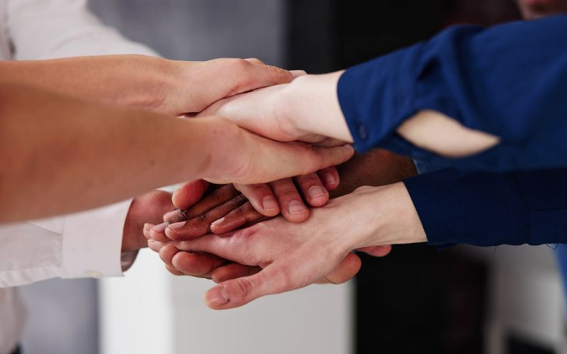 A bunch of hands on top of each other for a huddle